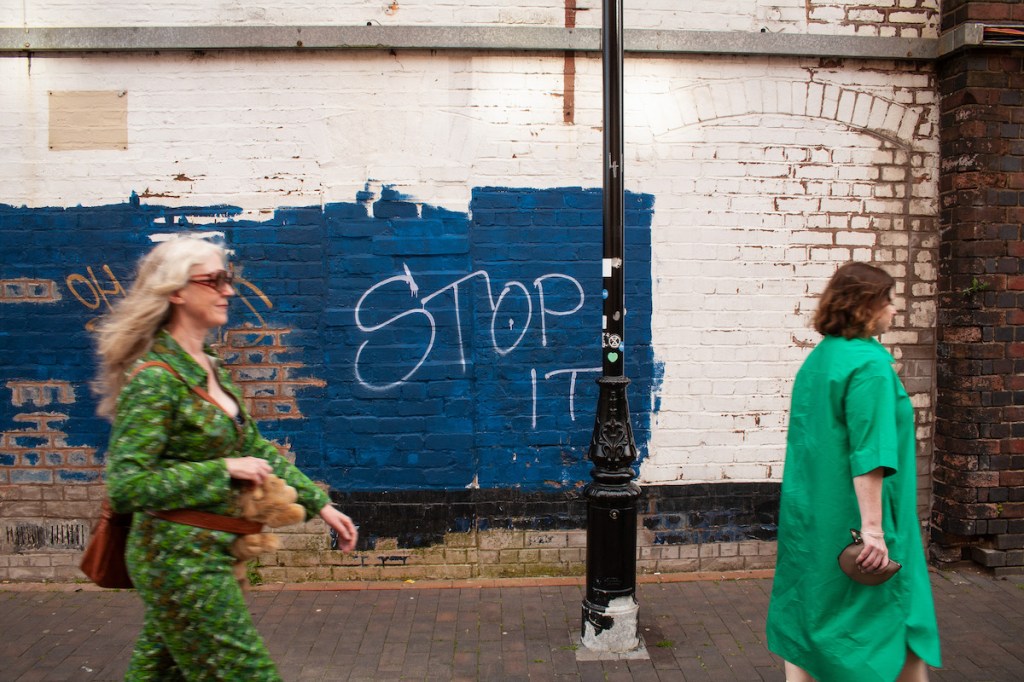 Two crones on canal towpath. A graffiti sign says Stop It.